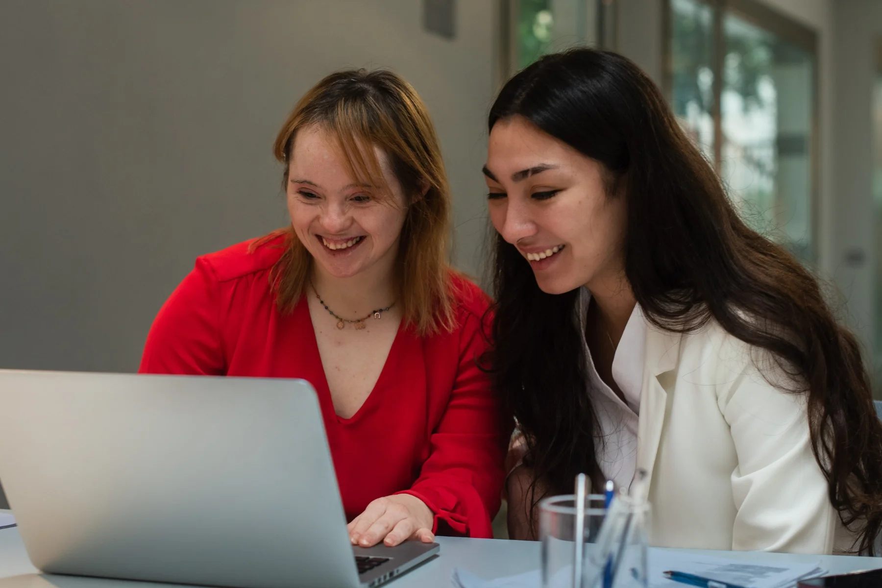 two ladies happily browsing a laptop