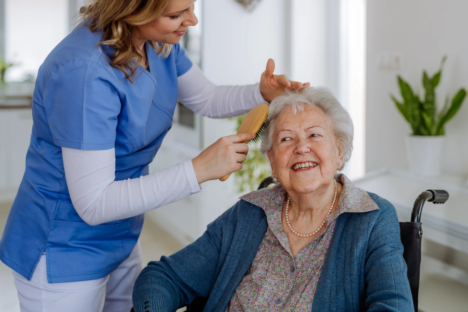 A woman combing an elderly person's hair